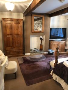 a living room with a fireplace and a tv at Over The Bridge Guest House in Ripponden