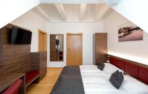 a bedroom with two beds and a flat screen tv at Hotel am See Rust in Rust