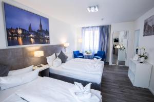 a hotel room with two beds with blue chairs at Appartementhaus Obertrave in Lübeck