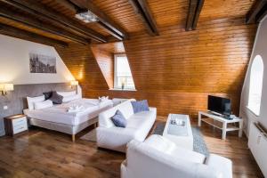 a living room with white furniture and a wooden wall at Appartementhaus Obertrave in Lübeck