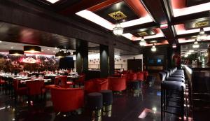 a restaurant with red chairs and tables and a bar at Maxime Hotel Lisbon in Lisbon