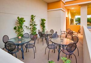 a group of tables and chairs on a patio at Wyndham Garden OKC Airport - Event Center, Indoor pool, Arcade Near Paycom, Fairgrounds in Oklahoma City
