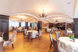 a dining room with white tables and chairs at Pensiunea Himalaya in Dărmăneasca