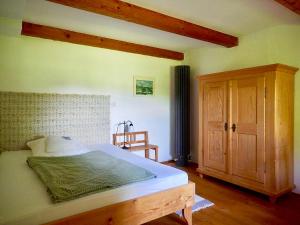 a bedroom with a large bed and a wooden cabinet at Ponzaunerhof in Hebertsfelden