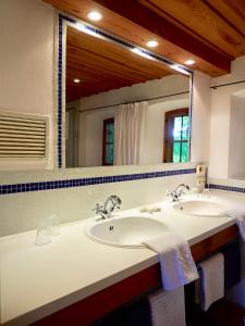 a bathroom with two sinks and a large mirror at Ponzaunerhof in Hebertsfelden