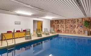 a swimming pool with chairs and a pool at Hotel Gersfelder Hof in Gersfeld