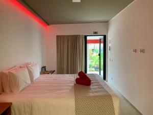 1 dormitorio con 1 cama con luz roja. en Villa 3 Caparica - Lisbon Gay Beach Resort, en Charneca