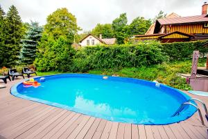 a large swimming pool on a wooden deck at Penzion Adélka Janské Lázně in Janske Lazne