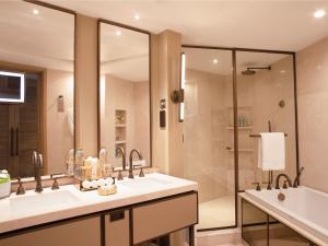 a bathroom with two sinks and a tub and a shower at Jumeirah Beach Hotel Dubai in Dubai