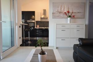 a living room with a couch and a kitchen at Penthouse Avangard in Pag