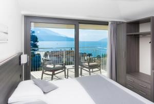 a bedroom with a bed and a balcony at Hotel Domaso in Domaso