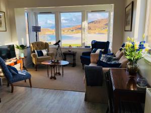 a living room with furniture and a large window at 3A Mellon Udrigle in Obinan