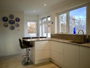 a kitchen with a counter and a sink and two windows at 3A Mellon Udrigle in Obinan