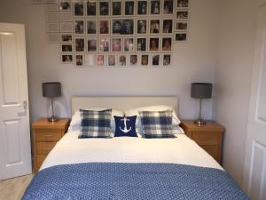 a bedroom with a bed with pillows and pictures on the wall at 3A Mellon Udrigle in Obinan