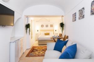 a living room with a white couch and a bed at Casa Candeias in Évora
