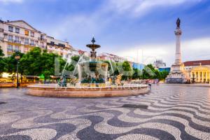 einen Brunnen auf einem Platz mit einem Turm im Hintergrund in der Unterkunft LovelyStay - Principe Real: modern and comfort! in Lissabon