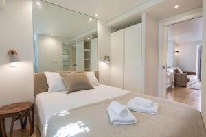 een slaapkamer met een groot wit bed en handdoeken bij LovelyStay - Principe Real: modern and comfort! in Lissabon