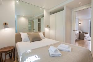 リスボンにあるLovelyStay - Principe Real: modern and comfort!のベッドルーム1室(大きな白いベッド1台、タオル付)