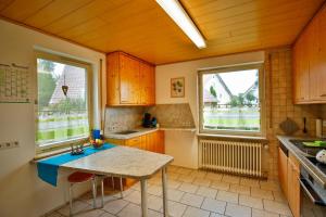 a kitchen with a table and two windows at Zimmervermietung Familie Kolb in Oberessendorf