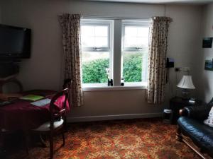 カイル・オブ・ロカルシュにあるCraig Cottageの窓、椅子、ソファが備わる客室です。