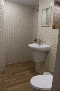 uma casa de banho com um WC branco e um lavatório. em Apartment 18 em Velingrad
