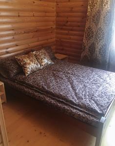 a bed in a room with a wooden wall at Гірський релакс in Golovetsk +34 photos