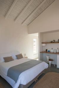 a bedroom with a large bed and a window at Alma Cheia Sunrise Studio Apartment in Odeceixe