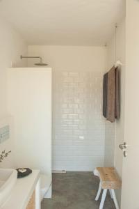 a white bathroom with a sink and a toilet at Alma Cheia Sunrise Studio Apartment in Odeceixe