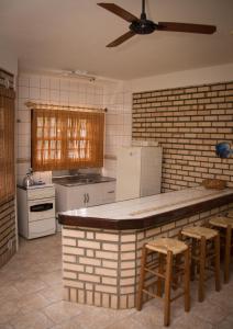 cocina con barra con taburetes y ventilador de techo en Pousada Mare Mansa, en Bombinhas