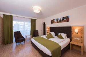 a hotel room with a large bed and a window at Genusshotel Almrausch in Bad Kleinkirchheim