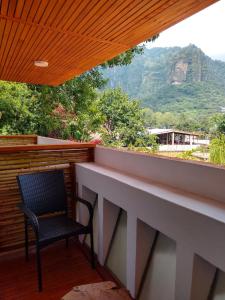 a chair on a balcony with a view of a mountain at Sierra Central By Chic Hotel Group in Tepoztlán +3 photos