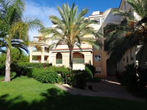 a large white building with palm trees in front of it at Cortes valencianas 45 in Náquera