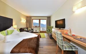 a hotel room with a bed and a desk at Hotel Lärchenhof in Maranza