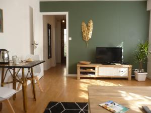 a living room with a flat screen tv and a table at 4 Clarence app avec parking Hyper centre Thonon in Thonon-les-Bains
