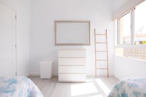 a bedroom with two beds and a tv on a dresser at Deluxe Apartment. 50 meters Beach in San Agustin +19 photos