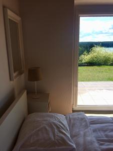 - une chambre avec un lit et une grande fenêtre dans l'établissement Pommern, Kaschubische Schweiz, Stezyca, à Żuromin