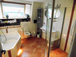 a bathroom with a shower and a sink and a toilet at B&B De Duinhoek in Beverwijk
