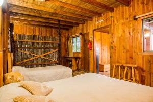 a bedroom with two beds in a wooden cabin at Apart hotel Puchaley Lafquen in Panguipulli +204 photos