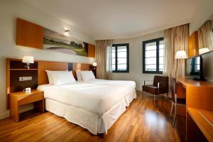 une chambre d'hôtel avec un lit et une télévision dans l'établissement Exe Estepona Thalasso & Spa- Adults Only, à Estepona