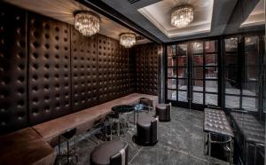 a bar with leather walls and stools and chandeliers at Aliz Hotel Times Square in New York
