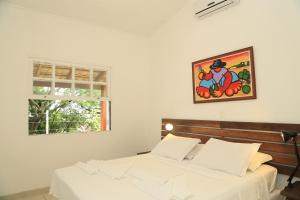 a bedroom with two beds and a picture on the wall at Chalés Mariolinha in Ilhabela
