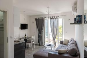 a living room with a couch and a table and a kitchen at " Tiamat " apartmani in Tivat