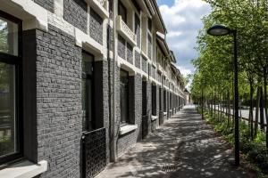 une allée en briques avec un éclairage de rue à côté d'un bâtiment dans l'établissement Hôtel Louvre-Lens - Esprit de France, à Lens