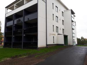 ロヴァニエミにあるSiljo Apartmentsの駐車場付きの白い大きな建物