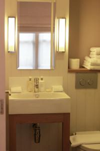 a bathroom with a white sink and a mirror at Fox and Grapes in London