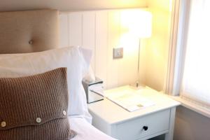 
a bed with a white comforter next to a lamp at Fox and Grapes in London
