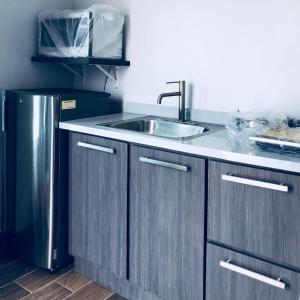 a kitchen with a sink and a refrigerator at Modern Suite #1 Pasavento in Aguadilla +19 photos