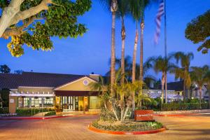a hotel with palm trees in front of a building at Clementine Hotel & Suites Anaheim in Anaheim
