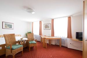 um quarto de hotel com uma mesa e cadeiras e uma televisão em Landgasthof Lamm em Aalen