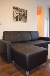 um sofá de couro preto numa sala de estar em Apartment Meli em Sesvete